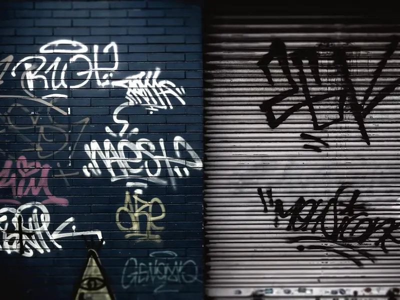 Mit Graffiti besprühte Ziegelwand und Rolltor